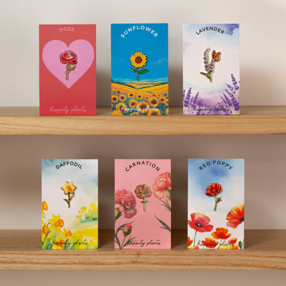 Collection of enamel pins in different flower designs by Happily Plants