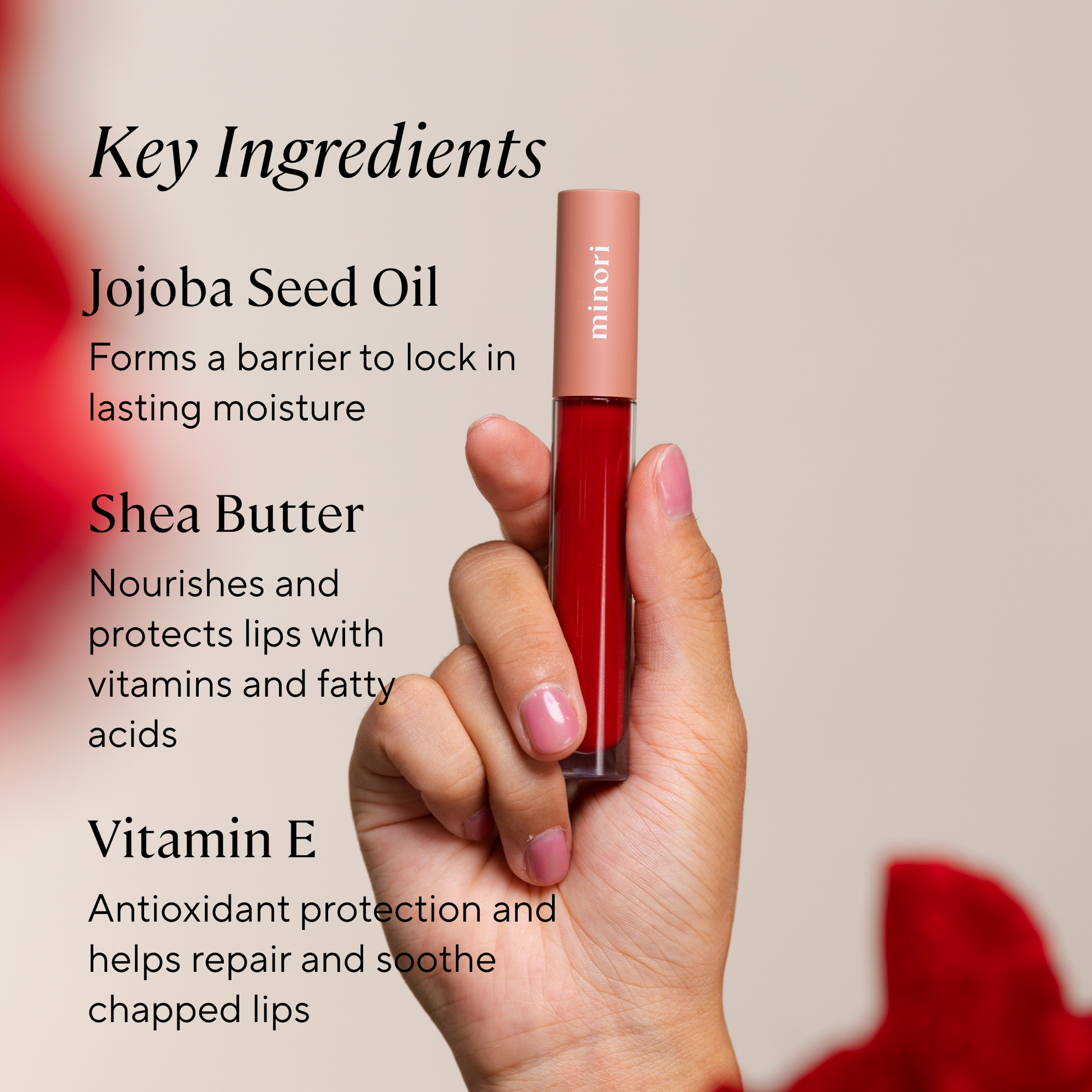 Red hydrating lip balm held by a hand with key ingredients jojoba, shea butter, vitamin e