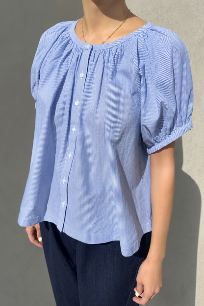 Woman wearing Le Bon Shoppe puff sleeve blouse in blue with buttons