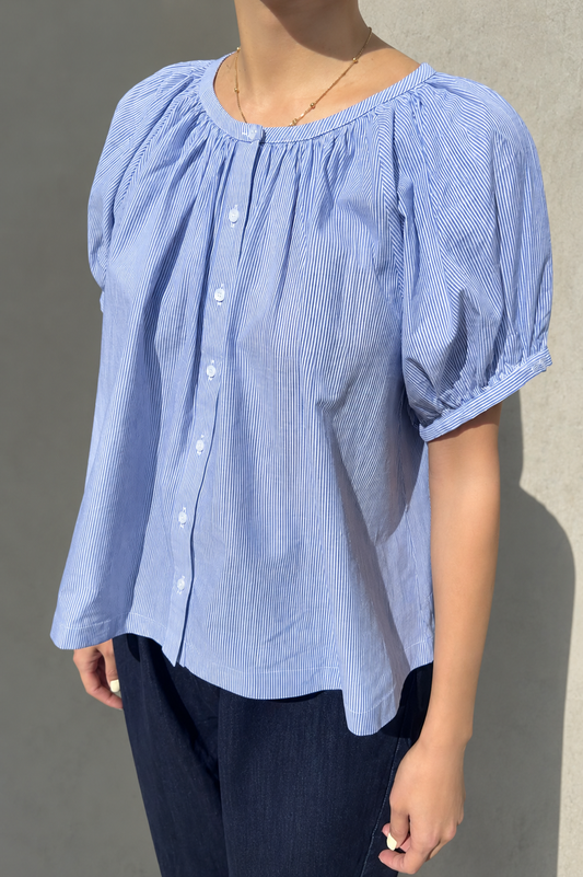 Woman wearing Le Bon Shoppe puff sleeve blouse in blue with buttons