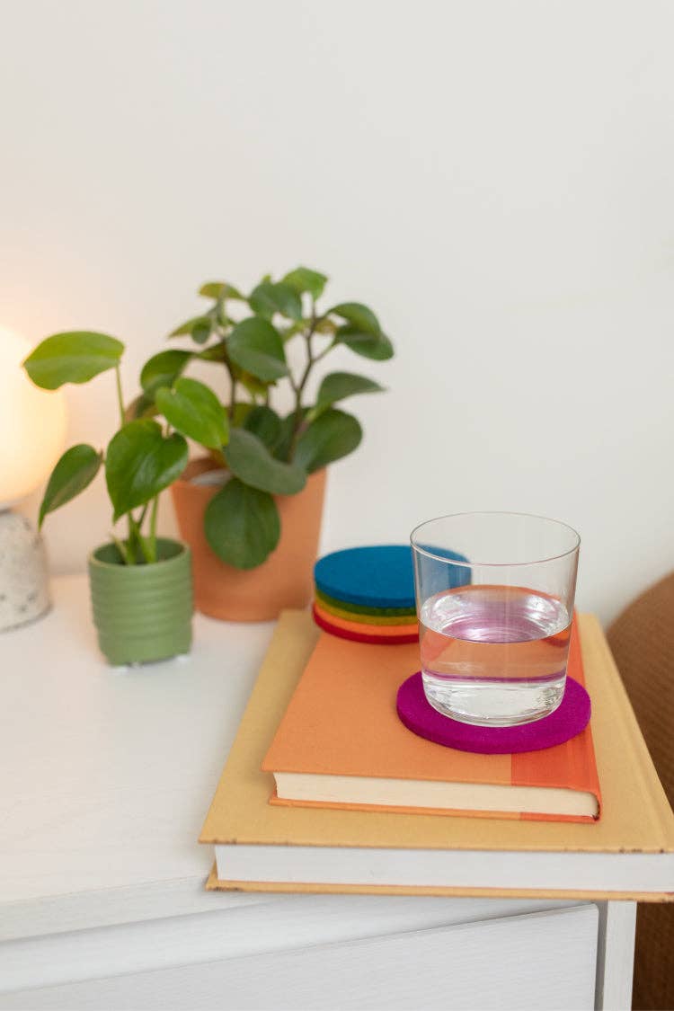 Colorful Graf Lantz wool coasters on a nightstand