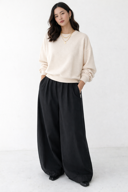 Woman wearing a beige sweater and black parachute pants by Le Bon Shoppe 
