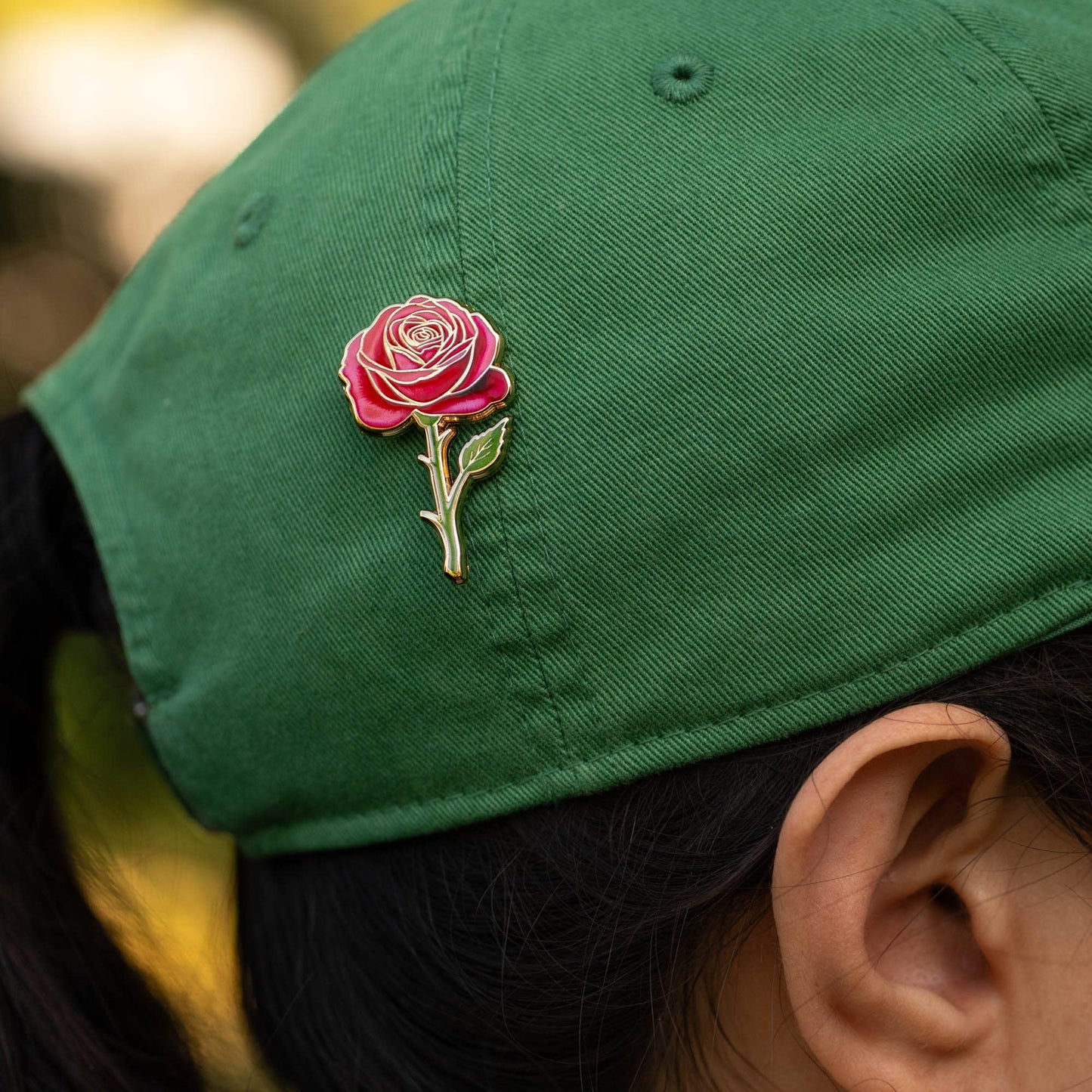 rose enamel pin on green cap