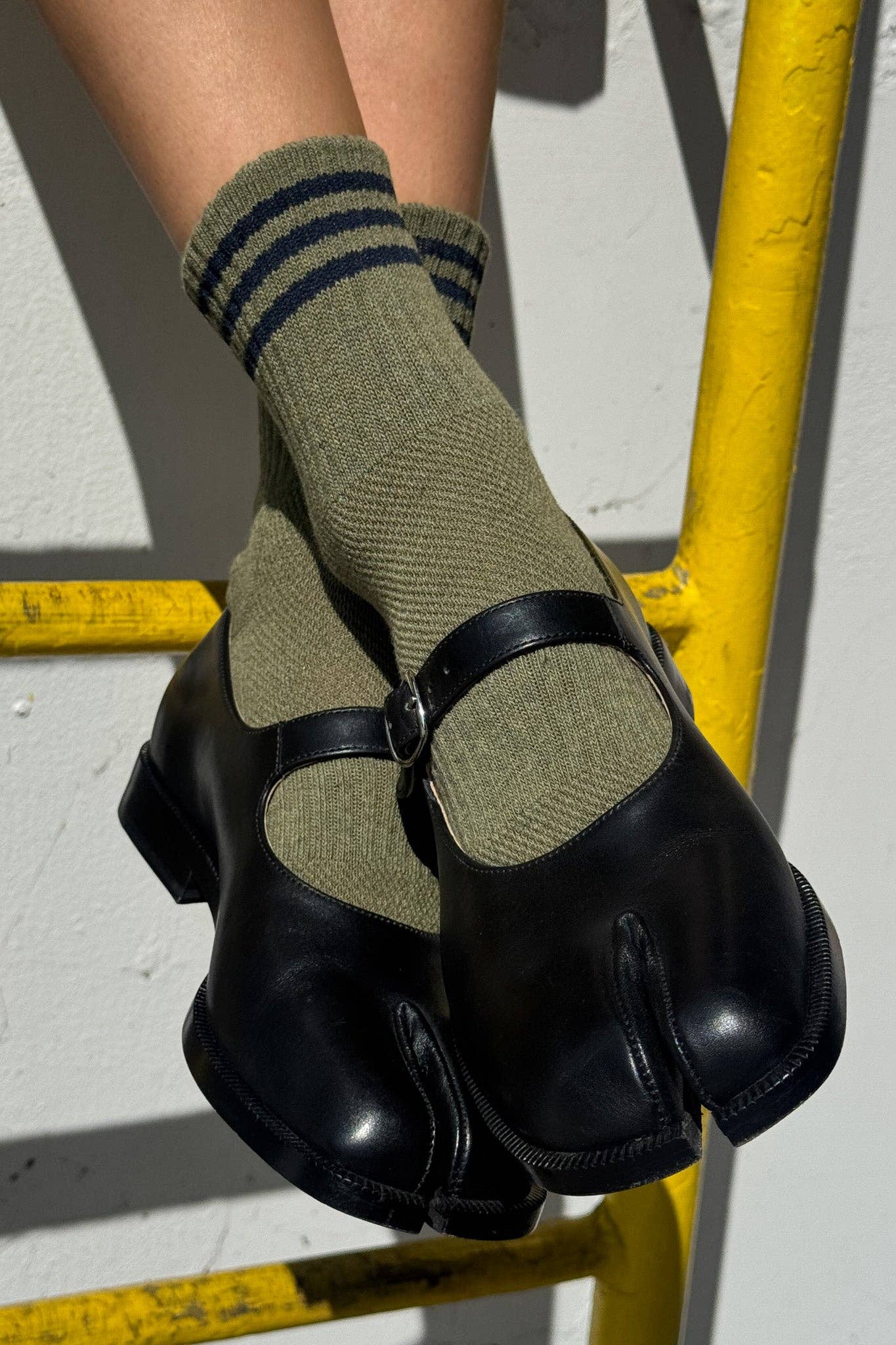Black shoes with green Le Bon Shoppe socks on woman