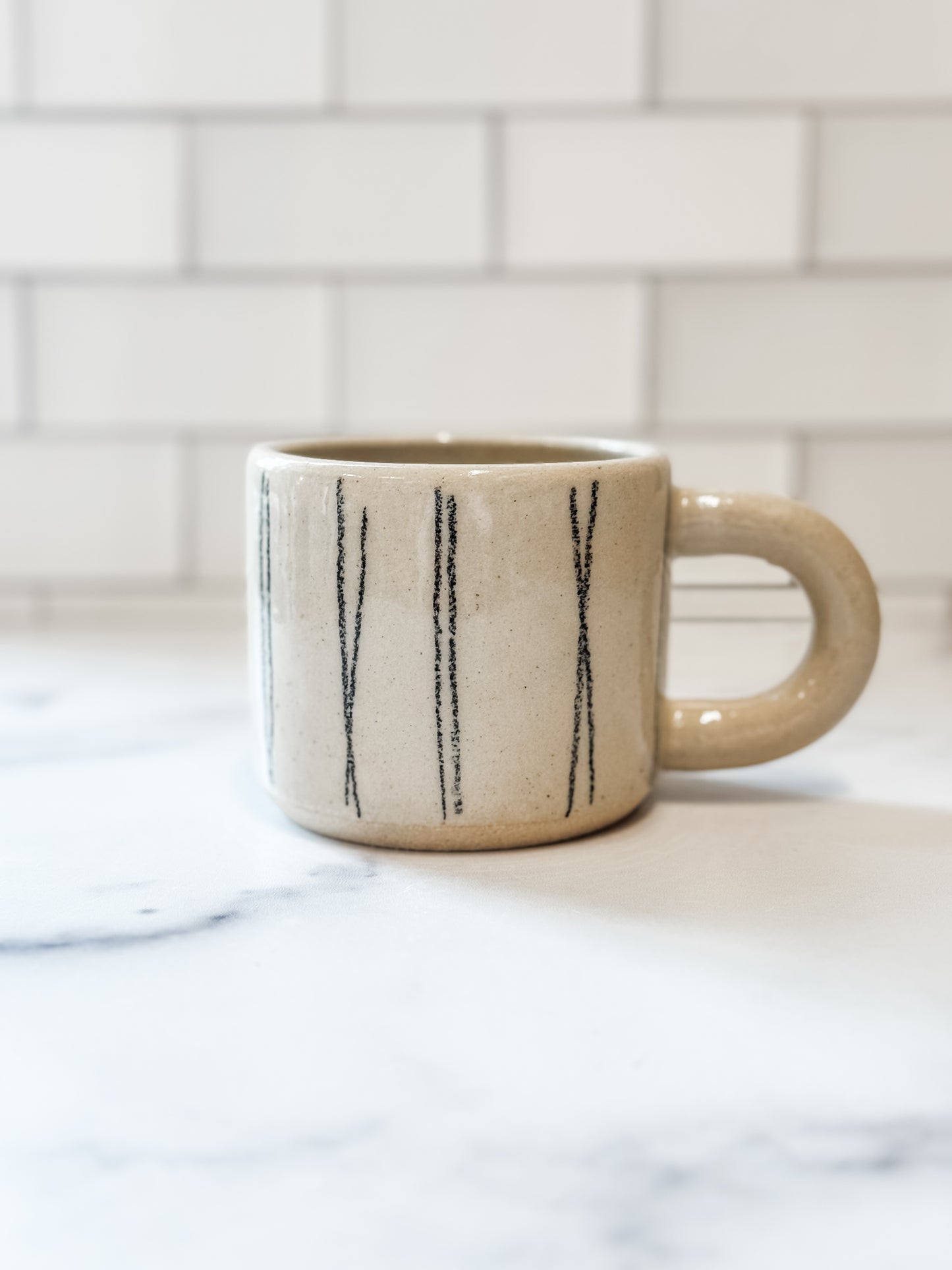 Beige ceramic mug with black vertical stripes handmade in Portland OR 
